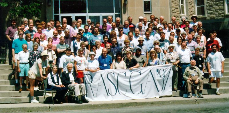 Delegates of the 1997 RASC General Assembly gathered on the steps in Kingston, holding a 'RASC GA '97' banner.